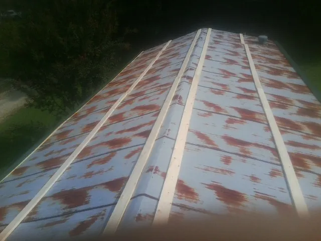 Rusted metal roof panels with new wood purlins before replacement — Storm Damage Roof Repair in Pleasantville by Roofing Brothers